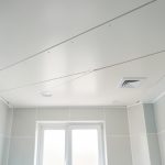 Installation soignée de lambris PVC au plafond d’une salle de bain moderne, avec finitions propres et matériaux résistants à l’humidité.