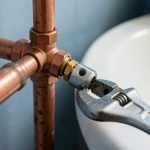 Gros plan sur le remplacement soigneux d’un robinet autoperceur qui fuit par une vanne d’arrêt à compression sur un tuyau en cuivre.